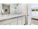 Bright bathroom with double sinks, granite counters, white cabinetry, and a view into the primary bedroom at 3501 Rosewood Ramble Ct, Plant City, FL 33565