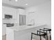 Modern kitchen with stainless steel appliances, sleek white cabinetry, breakfast bar with barstool seating at 400 150Th Ave # 206, Madeira Beach, FL 33708