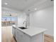 Modern white kitchen island with a sink and a view of the living room at 400 150Th Ave # 206, Madeira Beach, FL 33708