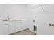 Clean laundry room with white cabinetry and a chrome hanging rack above at 400 150Th Ave # 206, Madeira Beach, FL 33708