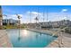 Inviting community pool surrounded by lounge chairs and views of a marina at 400 150Th Ave # 206, Madeira Beach, FL 33708