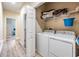 Functional laundry area includes washer, dryer, and shelving for storage at 450 Harbor Springs Dr, Palm Harbor, FL 34683