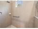 Bathroom shower with neutral-colored tiles, a window, and a grab bar at 450 Harbor Springs Dr, Palm Harbor, FL 34683