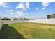 Back yard of home featuring green grass and white vinyl fencing for privacy at 4727 Lindever Ln, Palmetto, FL 34221