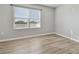 Bright, empty bedroom with a large window and light wood flooring at 4727 Lindever Ln, Palmetto, FL 34221