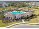 Aerial view showcases a community clubhouse with a pool, greenery, and surrounding homes at 4727 Lindever Ln, Palmetto, FL 34221