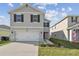 Two-story home showcasing a wide driveway, black shutters, and meticulously maintained landscaping at 4727 Lindever Ln, Palmetto, FL 34221