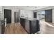 Modern kitchen island with stainless steel appliances and black cabinets, sliding barn door to backyard at 4727 Lindever Ln, Palmetto, FL 34221