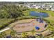 Aerial view of a community playground by a pond, highlighting surrounding greenery and residential houses at 4727 Lindever Ln, Palmetto, FL 34221
