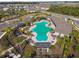 Aerial view of a community swimming pool with palm trees, lounge chairs, and clubhouse at 4727 Lindever Ln, Palmetto, FL 34221