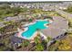 Aerial view of a community pool with palm trees, lounge chairs, and a shaded pergola at 4727 Lindever Ln, Palmetto, FL 34221