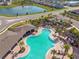 Aerial view of a resort-style pool featuring a covered area, seating, and lush greenery at 4727 Lindever Ln, Palmetto, FL 34221