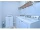 Bright laundry room with a washer, dryer, cabinet and shelves for easy organization at 6113 Plover Meadow St, Lithia, FL 33547