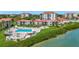 Stunning aerial view of a waterfront condo community with pool, lush landscaping, and coastal charm at 6268 Palma Del Mar S Blvd # 113, St Petersburg, FL 33715