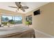 Bedroom featuring ocean view, ceiling fan, and sliding glass door leading to an outdoor space at 6268 Palma Del Mar S Blvd # 113, St Petersburg, FL 33715