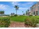 Beautifully landscaped grounds with lush green grass, tropical plants, and a glimpse of the sparkling beach at 6268 Palma Del Mar S Blvd # 113, St Petersburg, FL 33715