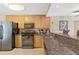 Modern kitchen showcasing stainless steel appliances, wood cabinets, and granite countertops for a sleek look at 6268 Palma Del Mar S Blvd # 113, St Petersburg, FL 33715