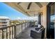 A spacious balcony with cushioned seating, dining table, and an impressive city view at 6500 Sunset Way # 501, St Pete Beach, FL 33706