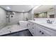 Modern bathroom featuring stylish white vanities, a soaking tub, and a glass-enclosed shower at 6500 Sunset Way # 501, St Pete Beach, FL 33706
