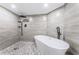 Modern bathroom featuring a freestanding tub, pebble stone floor, and stylish black fixtures at 6500 Sunset Way # 501, St Pete Beach, FL 33706