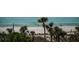 Scenic view of the beach with clear water and palm trees offering a relaxing coastal lifestyle at 6500 Sunset Way # 501, St Pete Beach, FL 33706