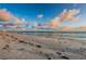 Scenic beach view with calm waves, soft sand, and a clear sky at 6500 Sunset Way # 501, St Pete Beach, FL 33706