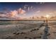 Scenic beach view with soft sand, gentle waves, and a vibrant sky at sunset at 6500 Sunset Way # 501, St Pete Beach, FL 33706