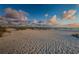Expansive sandy beach with tranquil water and scattered clouds at 6500 Sunset Way # 501, St Pete Beach, FL 33706