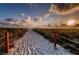 Sandy beach path leading to the ocean, lined with dune grass and a rope fence at 6500 Sunset Way # 501, St Pete Beach, FL 33706