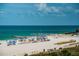 Beautiful beach scene with white sand, turquoise water, people enjoying the sun, and clear blue sky at 6500 Sunset Way # 501, St Pete Beach, FL 33706