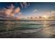 A scenic beach view with gentle waves and a person wading in the water at 6500 Sunset Way # 501, St Pete Beach, FL 33706