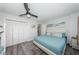 Comfortable bedroom with light blue decor, ceiling fan, wood-look floors, and closet space at 6500 Sunset Way # 501, St Pete Beach, FL 33706