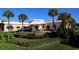 A beautifully landscaped community building featuring a covered entrance and colorful shrubbery at 6500 Sunset Way # 501, St Pete Beach, FL 33706