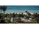 Community pool with lush tropical foliage and ocean view at 6500 Sunset Way # 501, St Pete Beach, FL 33706