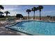 Community pool and hot tub overlooking the ocean with palm trees and lounge chairs for residents at 6500 Sunset Way # 501, St Pete Beach, FL 33706