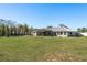 Large backyard featuring a covered patio, swimming pool, fenced yard, and ample green space at 6705 Myrna Dr, Tampa, FL 33619