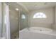 Bright bathroom featuring an oval tub and a glass-enclosed shower stall at 6705 Myrna Dr, Tampa, FL 33619