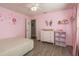 Bright pink bedroom with wood floors and a charming butterfly mirror at 6705 Myrna Dr, Tampa, FL 33619