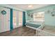 Light green bedroom featuring wood floors, twin bed and crib at 6705 Myrna Dr, Tampa, FL 33619
