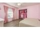 Pink bedroom features wood floors, closet organizer, and natural light at 6705 Myrna Dr, Tampa, FL 33619