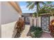 Inviting courtyard entrance featuring decorative iron gates, lush plants, and a patterned brick walkway at 672 Boca Ciega Point N Blvd, St Petersburg, FL 33708