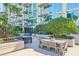 Beautiful outdoor seating area with multiple tables, lush landscaping, and views of the building and palms at 777 N Ashley Dr # 915, Tampa, FL 33602