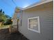 The exterior of the home features gray siding with white trim, a small wood deck, and well-maintained landscaping at 8101 N Alaska St, Tampa, FL 33604