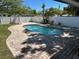 Private in-ground pool with brick patio, surrounded by a white fence, offering a serene backyard oasis at 9 N Aurora Ave, Clearwater, FL 33765