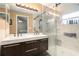 Modern bathroom featuring a double sink vanity, decorative mirror, and a glass door shower with modern fixtures at 918 W Knollwood St, Tampa, FL 33604