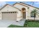 Welcoming home featuring an attached garage, a charming front entrance, and fresh landscaping at 918 W Knollwood St, Tampa, FL 33604