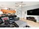 Open floorplan living room with ceiling fan, kitchen bar, and comfortable black leather couch at 918 W Knollwood St, Tampa, FL 33604