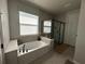 Bathroom featuring a soaking tub and a separate glass-enclosed shower at 921 Night Song St, Valrico, FL 33594