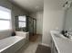 Bathroom featuring a soaking tub and a separate glass-enclosed shower at 921 Night Song St, Valrico, FL 33594