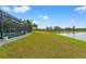 Expansive backyard with direct lake access and a screened-in pool area at 9846 Smarty Jones Dr, Ruskin, FL 33573